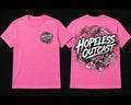 A pink short-sleeve t-shirt shown from both front and back. The front features a small circular graphic on the left chest, and the back features a large circular graphic with the text 'HOPELESS OUTCAST' in white stylized lettering over a black and gray design.